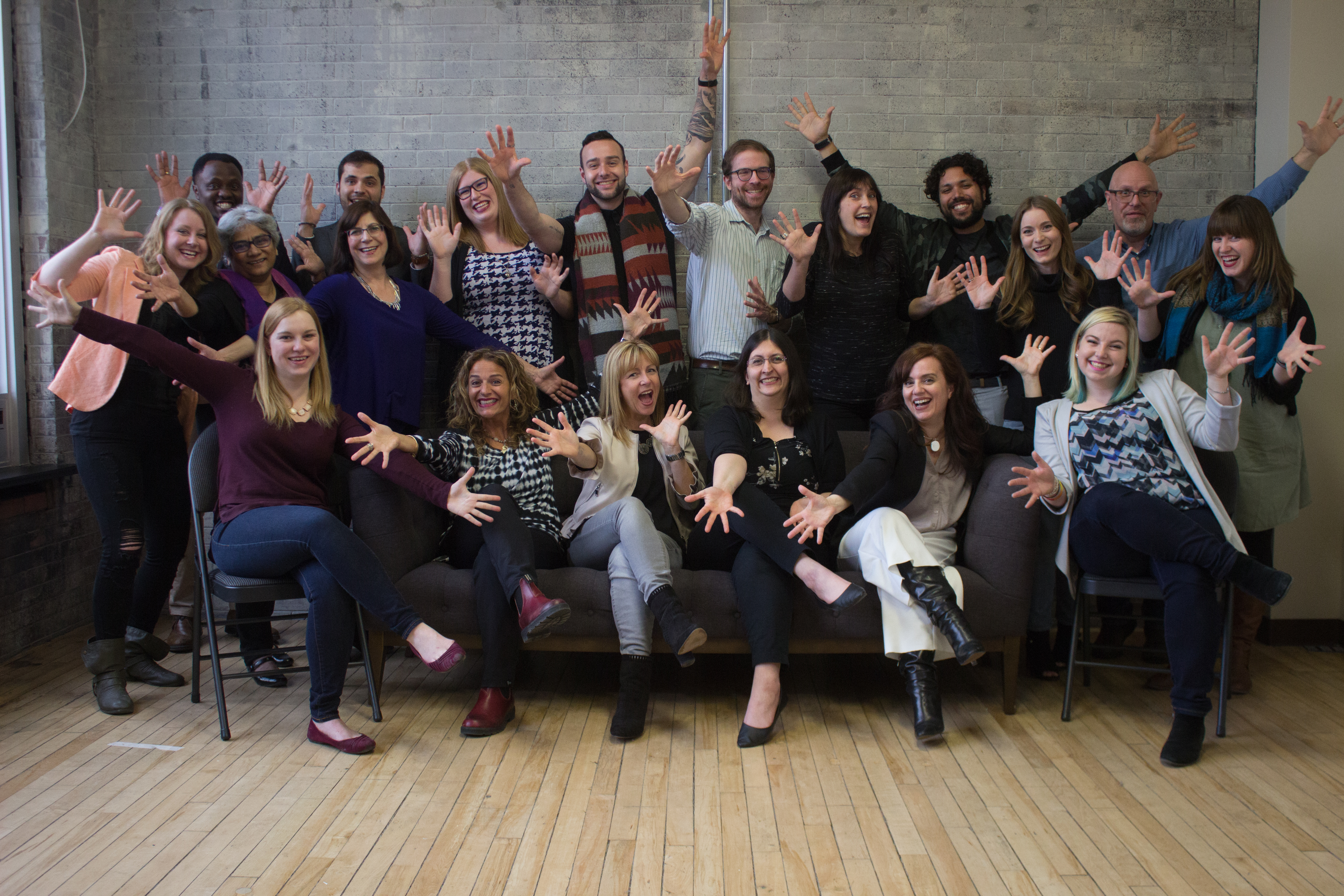 Large Group of Pillar Consultants standing together, smiling and waving arms and hands